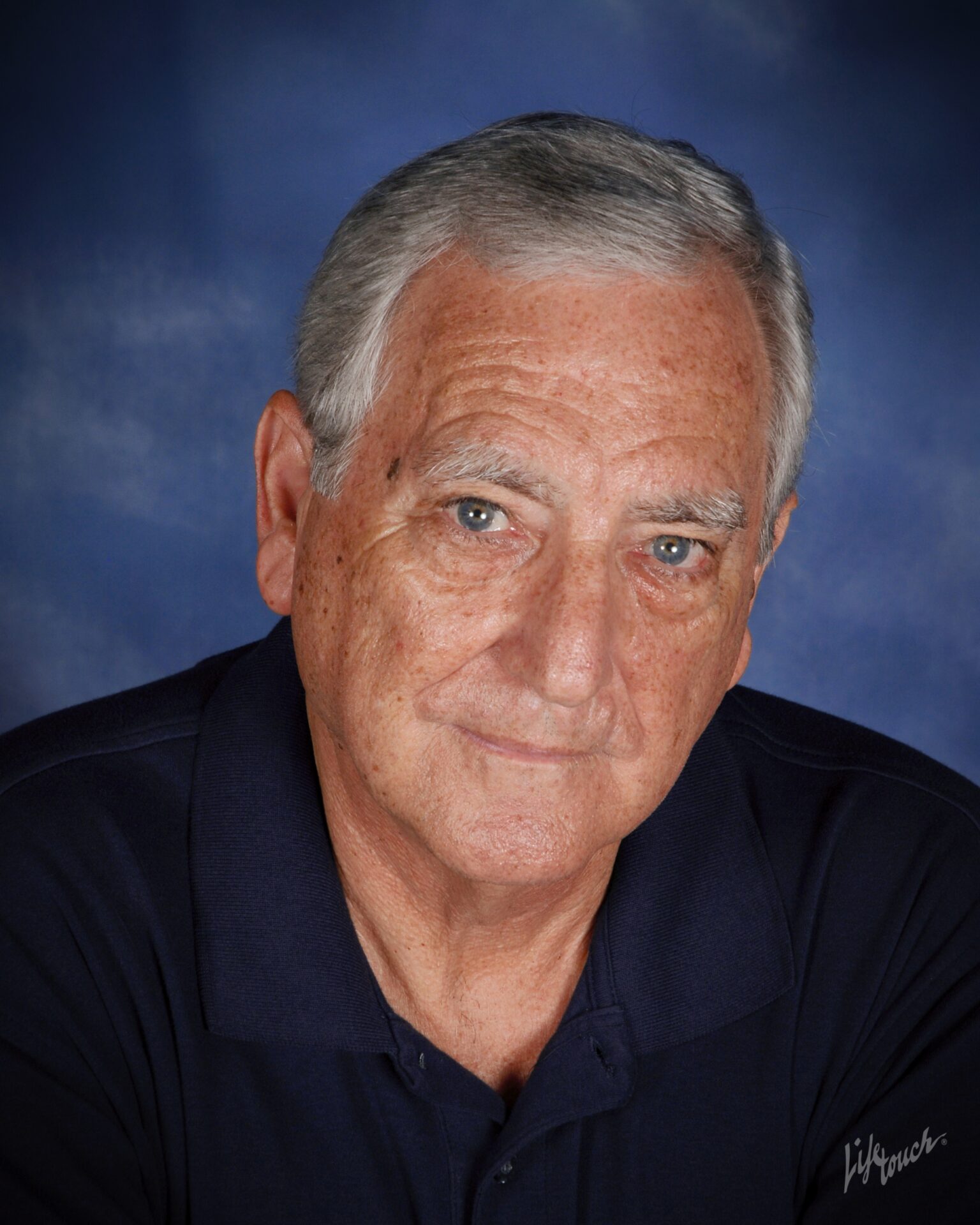 A man with grey hair and wearing a black shirt.