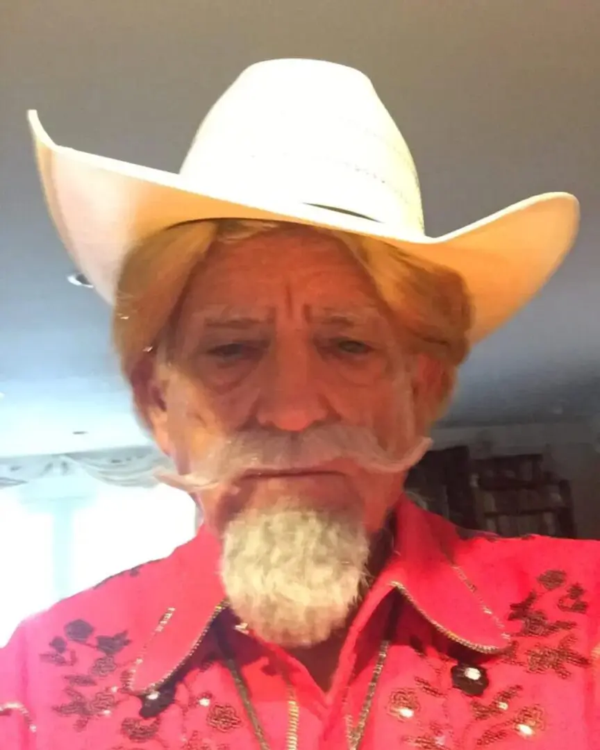 A man with long white beard wearing a cowboy hat.